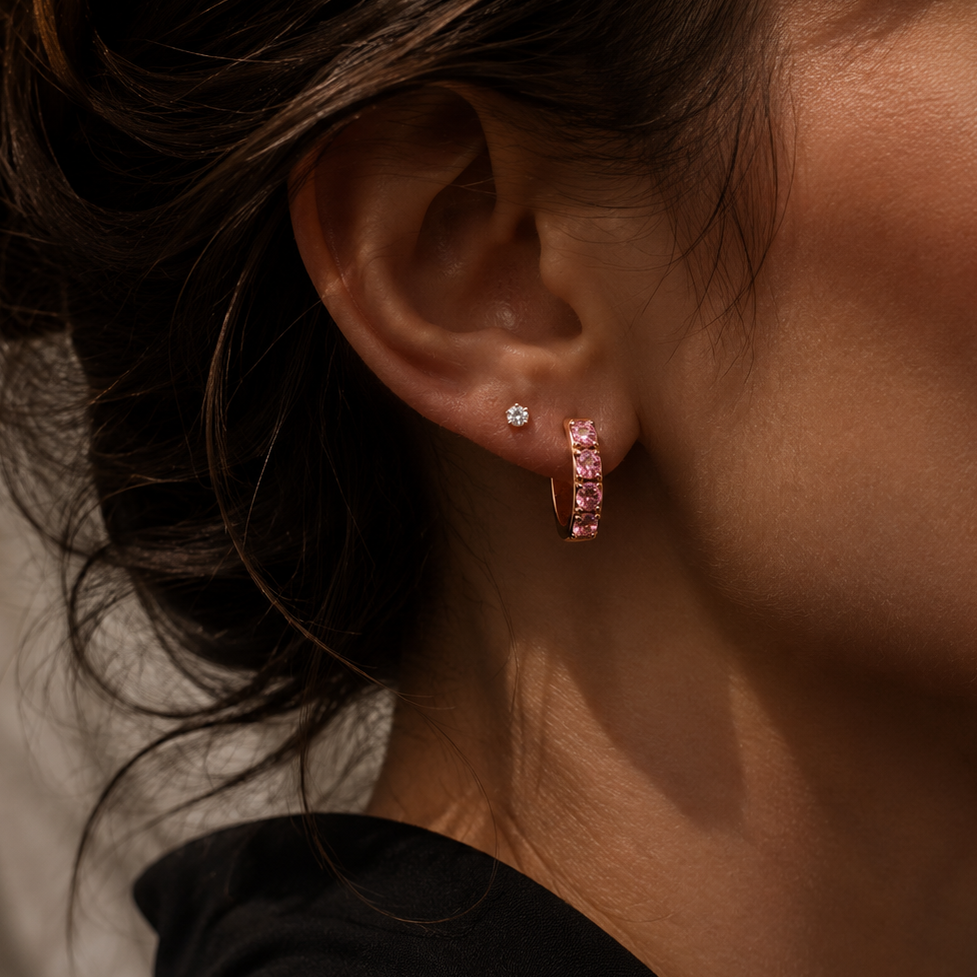 Close-up of a person wearing earrings with a neutral background