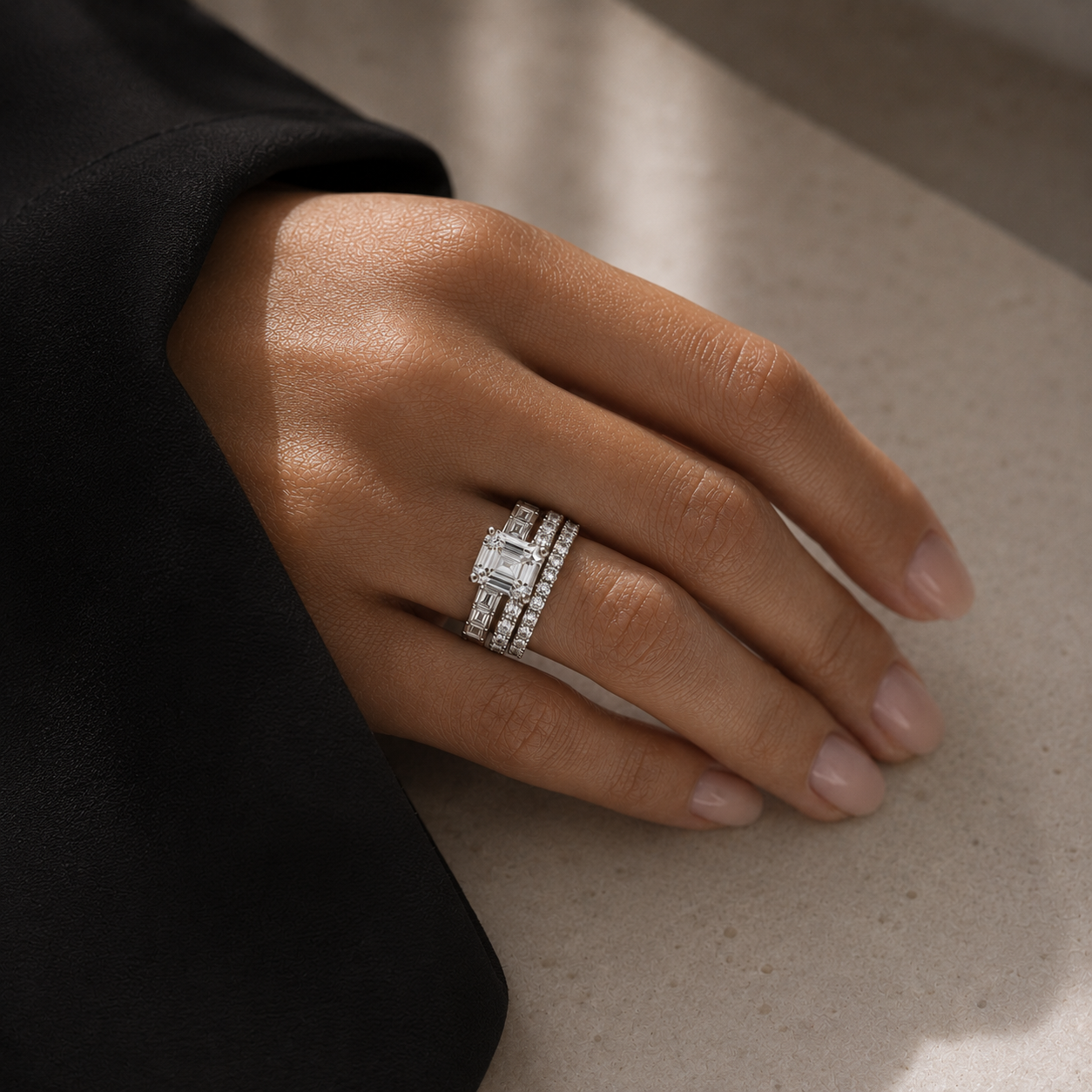 Hand wearing a diamond ring on a neutral background