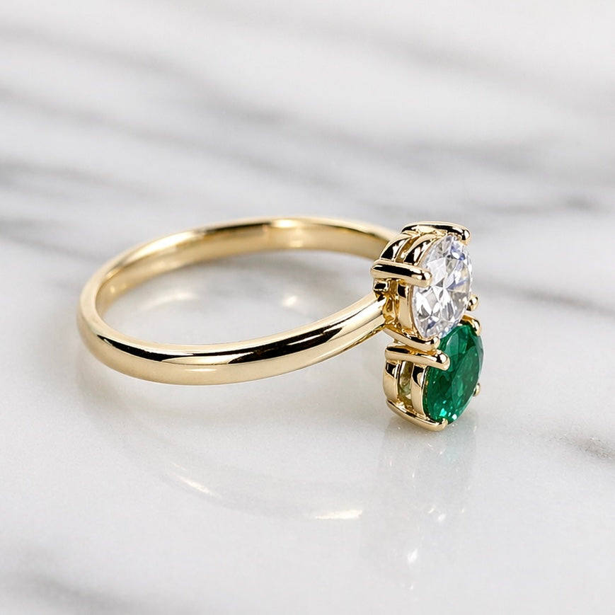 Gold ring with a green gemstone and clear stones on a white background