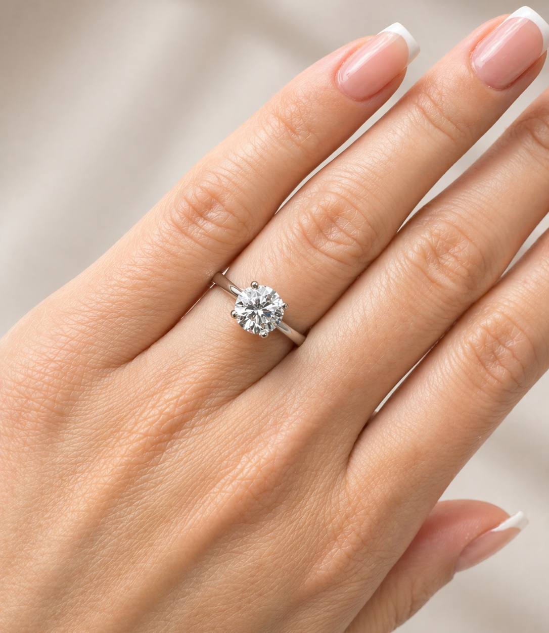 Diamond ring on a hand with a neutral background